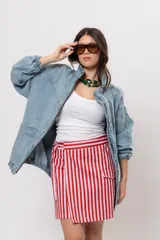 Pollera short cruzada con diseño a rayas verticales rojas y blancas, cintura elástica y bolsillos laterales cargo.