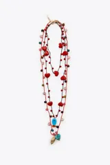 Pack de tres collares de cordones trenzados en tonos rojo y negro, adornados con cuentas de diferentes colores y dijes colgantes: corazones rojos, un dije azul turquesa con forma de pez, un dije azul verdoso con forma de corazón y un dije dorado con textura de concha.