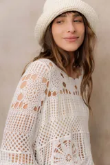 Gorro tipo bucket tejido a crochet de trama abierta, color natural, con ala corta y flexible.