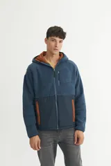 Campera con capucha en sherpa doble faz combinada con nylon de alta calidad. Detalle capitoneado con bolsillos en laterales. Bolsillo en pecho. Cierres engomados.