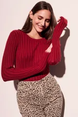 Sweater de punto acanalado en color negro con sutil acabado brillante. Presenta un diseño ajustado al cuerpo, cuello redondo y mangas largas.