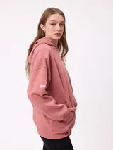 Canguro color crema con capucha y estampado grande en la espalda de un sol con un ojo, montañas, mariposas y texto.