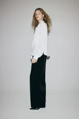 Pantalón de tiro alto de velour negro, de corte recto con pinzas y cintura elástica.
