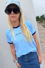 Remera de algodón color celeste con cuello y puños de manga corta en contraste azul marino. Presenta una frase bordada en la parte delantera.