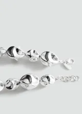 Collar de metal plateado con diseño de cuentas de formas orgánicas y abstractas, con cadena de ajuste y cierre de mosquetón.