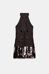 Vestido corto de cuello halter con espalda descubierta, diseño con frunces en el cuerpo y bajo con lentejuelas brillantes. Cuenta con forro interior y cierre trasero con cremallera oculta.