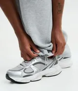Pantalón de corte baggy confeccionado en algodón con felpa, color gris melange. Presenta cintura elástica con cordón ajustable, bolsillos laterales y bajo con regulador elástico.