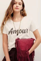 Remera de algodón blanca de manga corta y cuello redondo, con aplicación de pedrería formando la palabra "Amour" en el frente.