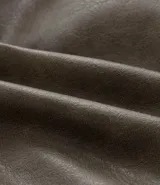 Campera bomber de poliuretano con acabado efecto cuero, cuello redondo, cierre frontal con cremallera, bolsillos delanteros y bolsillo utilitario en la manga. Presenta puños y ruedo elásticos, con forro interior en contraste.