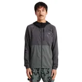 Campera deportiva gris con capucha negra, cierre frontal completo, bolsillo en el pecho con cierre y logo estampado en el hombro.