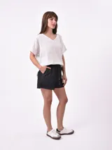 Short de jean oscuro, tiro alto, con cintura elástica fruncida y cordón ajustable. Presenta costuras en contraste y bolsillos laterales.