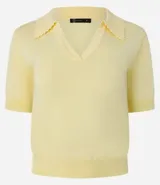 Blusa negra de punto con cuello polo, escote en V y mangas cortas. Detalle de mini perlas aplicadas en el cuello.