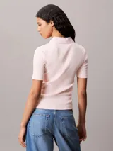 Chomba de Calvin Klein Jeans confeccionada en tejido de algodón con textura acanalada. Presenta cuello tipo polo con cartera de dos botones, mangas cortas y una insignia distintiva de la marca aplicada en el pecho.