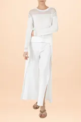Blusa de tejido de punto color blanco, con cuello redondo, mangas largas y detalle de textura acanalada en la parte superior y en los puños.
