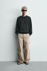 Sudadera de corte relaxed fit confeccionada en tejido de algodón con interior de rizo. Presenta cuello redondo, manga larga y acabados en rib, con un acabado de efecto lavado que le otorga una apariencia única.