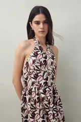 Vestido midi con estampado abstracto en blanco y negro, escote halter y falda acampanada con abertura frontal.