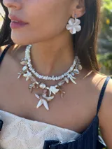 Collar corto con cuentas de nácar en diferentes formatos, perla natural XL y medallón de resina. Se cierra con cadena de acero quirúrgico y ganchito para regular el largo.