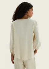 Blusa de viscosa color marrón, con escote en V profundo, mangas tres cuartos abullonadas y puños elásticos.