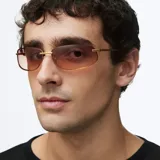 Lentes de sol con diseño envolvente de estilo Y2K, montura metálica dorada y cristales rectangulares con degradado en tonos marrones.