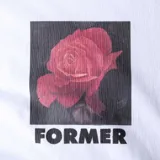 Remera blanca de manga corta con estampa de una rosa roja y el logo de la marca en el frente.