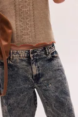Pantalón jean de algodón con corte barrel y tiro bajo, de color azul, con bolsillos delanteros y traseros.