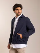 Campera azul marino con cierre frontal, cuello camisero y logo bordado en el pecho.