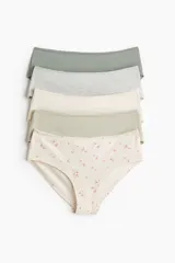 Pack de cinco bombachas estilo hipster de algodón, de tiro medio y cobertura media. Incluye tres lisas en tonos verde militar, gris melange y beige, una lisa en tono verde claro y una estampada con diseño floreado sobre fondo beige.
