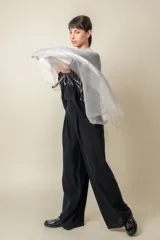 Chal de organza con tejido de lurex brillante, diseño ligero y traslúcido con terminación de flecos en los extremos.