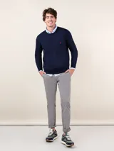 Pantalón chino azul marino de corte slim fit, confeccionado en gabardina con 77% algodón, 20% de algodón reciclado y 3% elastano. Presenta bolsillos delanteros y traseros. Tiene un lavado final con enzima ácida que le da un aspecto desgastado.