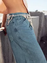 Pantalón de jean celeste de corte ancho, con cintura alta y detalle de crochet en la cintura.