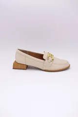 Mocasines de cuero en tono bronce metalizado, con detalle de aplique metálico dorado en el empeine y taco cuadrado bajo de madera.