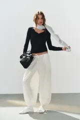 Pantalón confeccionado en mezcla de algodón y poliamida, color blanco, de tiro medio con cintura elástica y cordón ajustable. Posee bolsillos laterales y bajo abullonado con terminación en elástico.