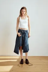 Falda midi de denim azul con tiro medio, diseño asimétrico de bajo cruzado y cinco bolsillos clásicos.