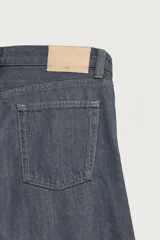 Jeans de corte straight fit, color gris oscuro, confeccionados en denim de algodón rígido, con diseño de cinco bolsillos y cierre frontal con cremallera y botón.