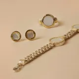 Pulsera de diseño articulado que combina eslabones de plata trenzada con detalles en oro y piezas circulares de nácar engarzadas.