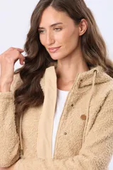Campera beige con capucha y cordones ajustables, combinada en su parte superior con tejido de corderito y en su parte inferior con diseño capitoné. Cuenta con cierre frontal y broches a presión, además de bolsillos laterales.
