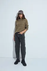 Sweater de punto gris con cuello a la base y diseño de trama geométrica en relieve. Presenta un calce relajado con mangas largas y puños tejidos.