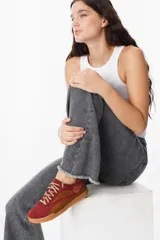 Zapatillas urbanas de cuero con diseño bicolor en tonos camel y negro, con cordones jaspeados y suela de goma color caramelo.