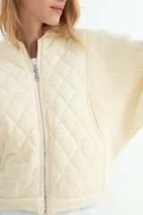 Campera tipo bomber con frente acolchado en diseño de rombos y mangas de tejido de punto acanalado. Presenta cierre frontal metálico y cuello, puños y ruedo en tejido elástico.