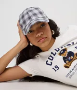 Gorra de aba curva confeccionada en franela de algodón, con diseño a cuadros en tonos gris, celeste y blanco, paneles estructurados y cierre regulable trasero con hebilla metálica.