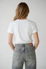 Remera de algodón color gris oscuro con cuello redondo y mangas cortas, decorada con pequeñas cuentas esféricas en tonos negro y plateado distribuidas por toda la prenda.