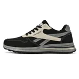 Championes deportivos de estilo retro, combinando malla blanca, gamuza gris y detalles en beige y negro. Suela gruesa blanca con capas grises y detalles dorados.