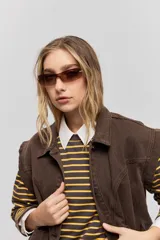 Chaleco de jean negro, de calce relajado con hombros caídos, cuello camisero, cierre frontal con botones y grandes bolsillos aplicados.
