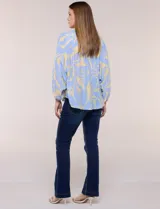 Blusa de gasa texturizada color celeste con estampado abstracto en tono amarillo, de silueta holgada y fluido diseño. Presenta escote en V con cuello a la base y abotonadura frontal con botones a tono. Cuenta con mangas largas abullonadas con puños elastizados.