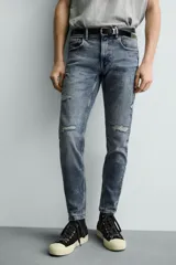 Jeans skinny fit de corte ajustado y tiro medio en color negro con efecto lavado y detalles desgastados. Confeccionados en tejido elástico con mezcla de algodón, presentan diseño clásico de cinco bolsillos y cierre frontal con cremallera y botón.