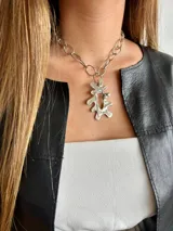 Collar plateado con cadena de eslabones grandes y dije abstracto con textura irregular.