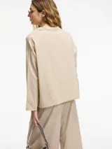 Camisa de algodón con cuello camisero y cierre frontal de botones. Presenta un corte holgado y mangas largas.