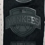 Short deportivo negro de tela de red, con cintura elástica ajustable con cordón. Estampado con el nombre "New York" en letras grandes y el logo de los Yankees.