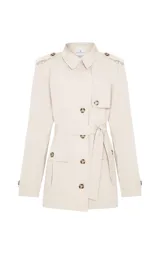 Trench corto Le Lis Blanc modelo Georgia, color beige, de corte recto, con cuello con solapa, doble botonadura frontal con botones carey, bolsillos delanteros con solapa y cinturón ajustable para la cintura.