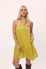 Vestido corto de cuello halter con espalda descubierta y falda con volado en el ruedo.